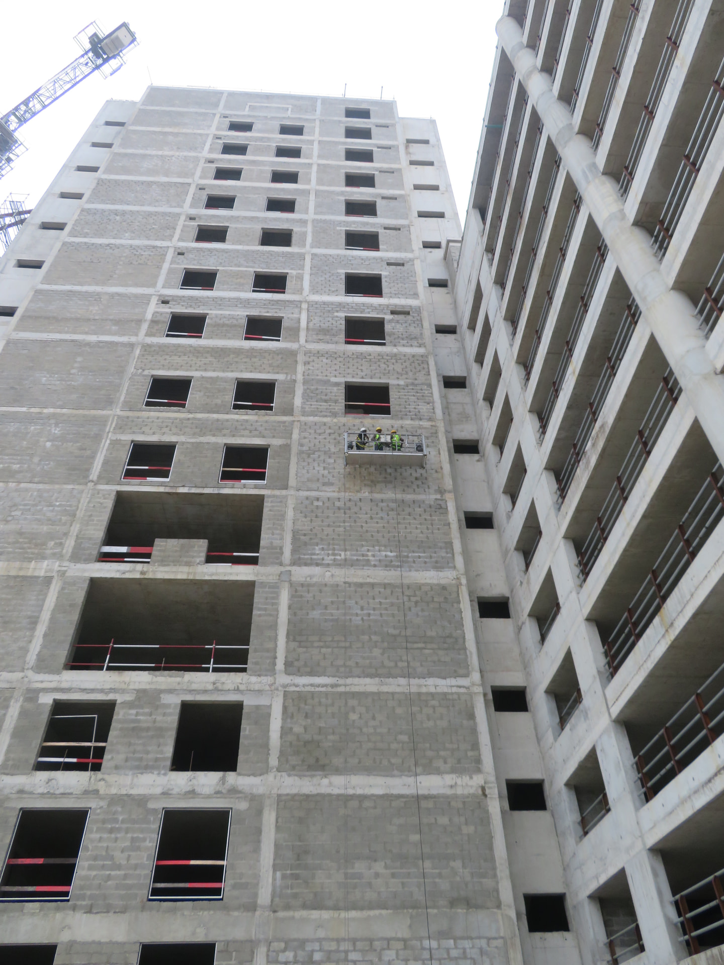 Cradle crew waterproofing a high-rise facade